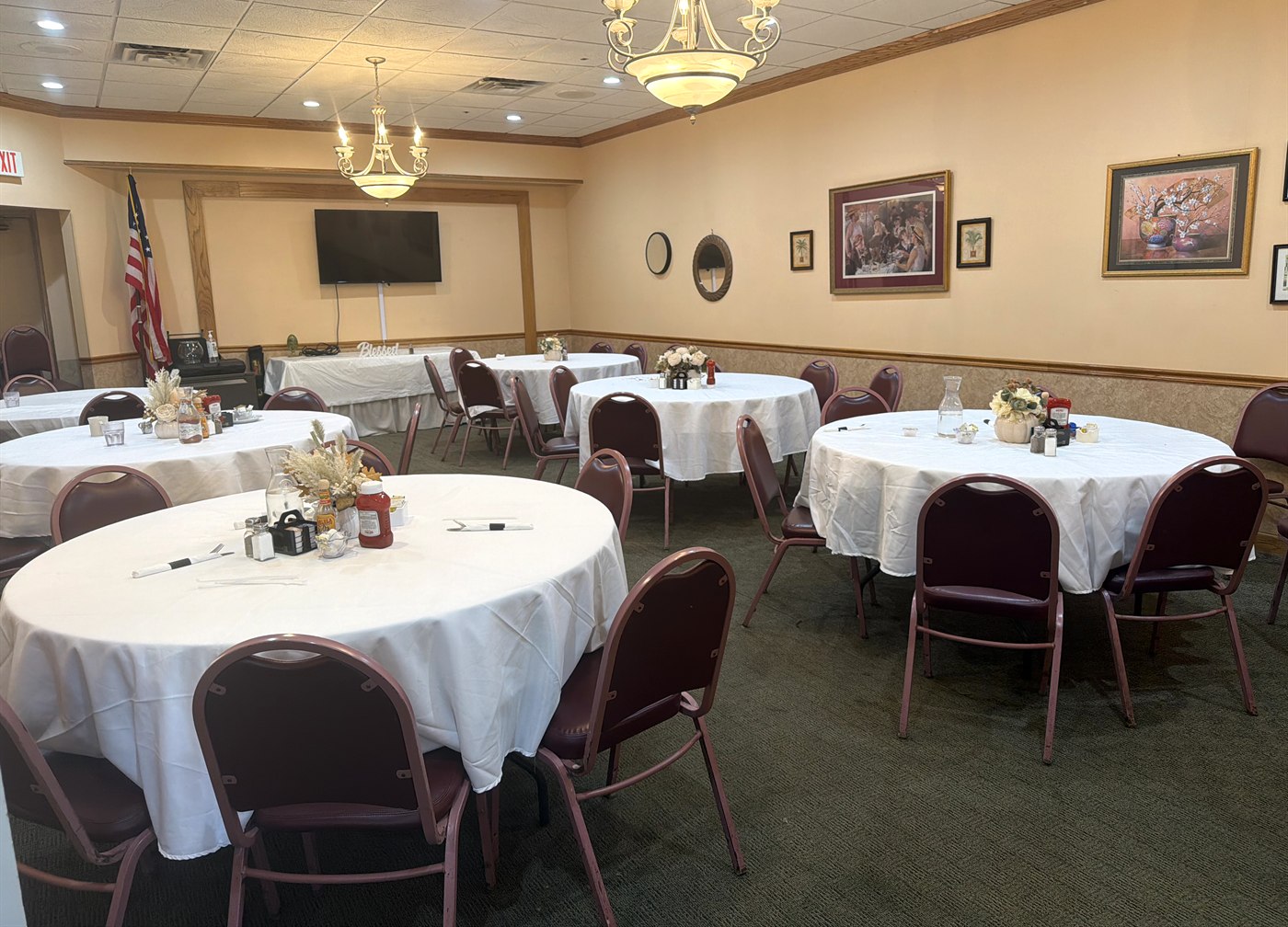 The private event room at Apple Villa, set with round tables, white tablecloths and flowers